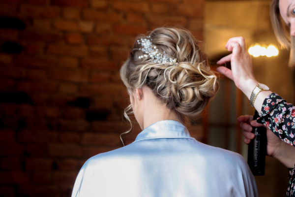 Una parrucchiera sta truccando una sposa nel giorno del suo matrimonio. Questo servizio è da affiancare al servizio di trucco sposa a palermo